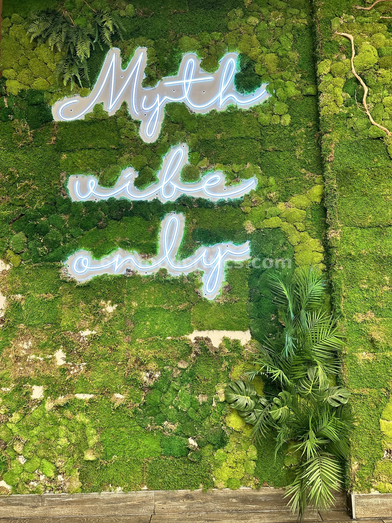 Moss wall with a neon Myth vibe only sign at Myth Szechuan