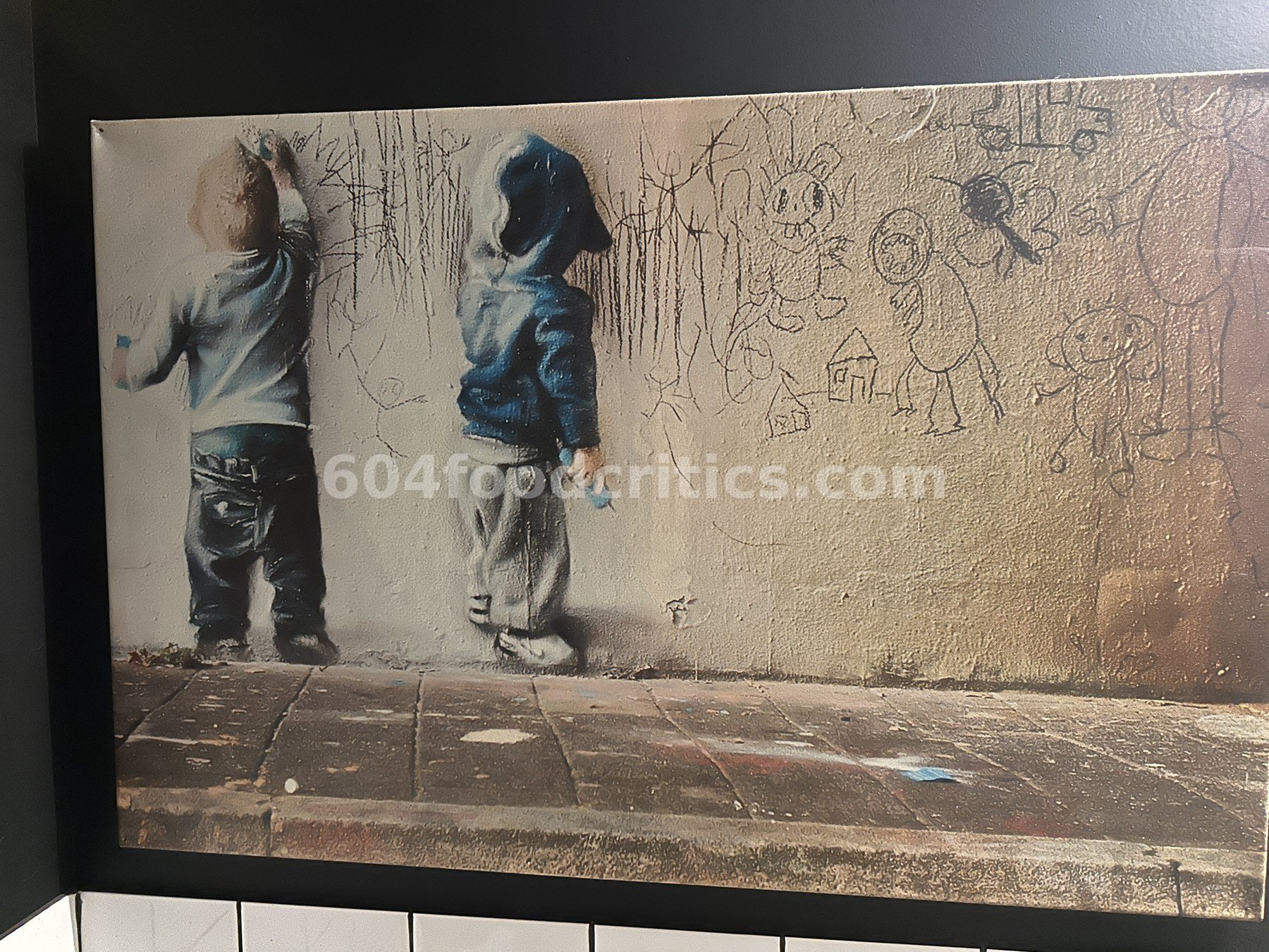 Canvas print of two small boys scribbling chalk drawings on a city wall